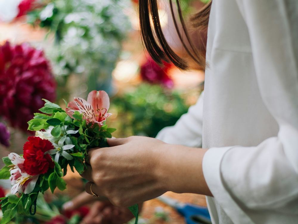 Une fleuriste qui arrange des fleurs dans sa boutique